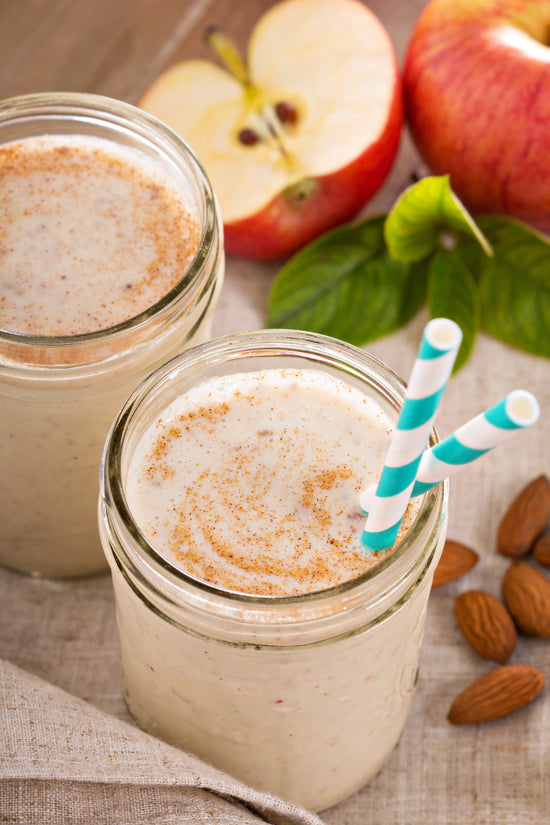 Milkshake jaune dans de petits pots avec 2 pailles accompagnés d'amendes sur le côté